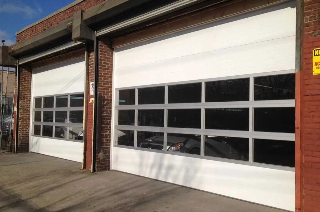 Two full-view aluminium and glass commercial overhead doors on a brick building